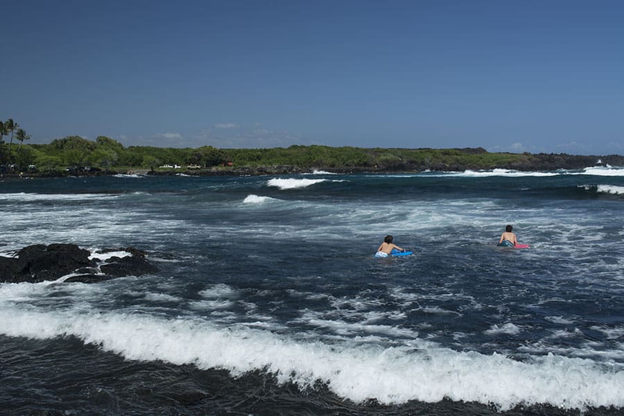 Kids swimming in the sea at the Black Sand Beach