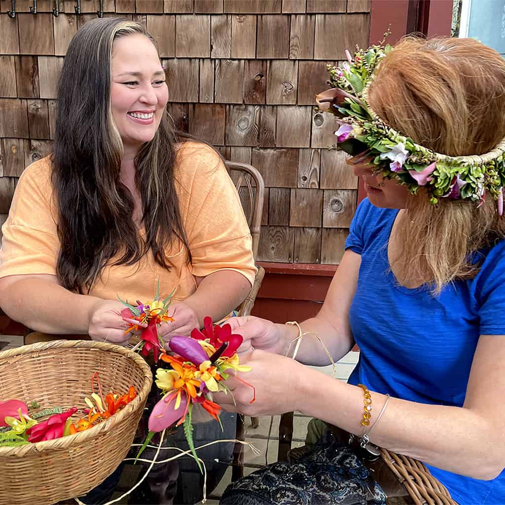 Two women making flower leis