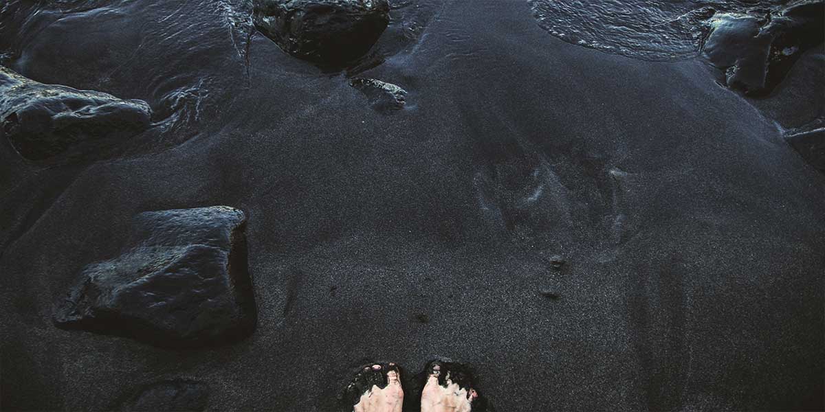 feet shot on black sand beach