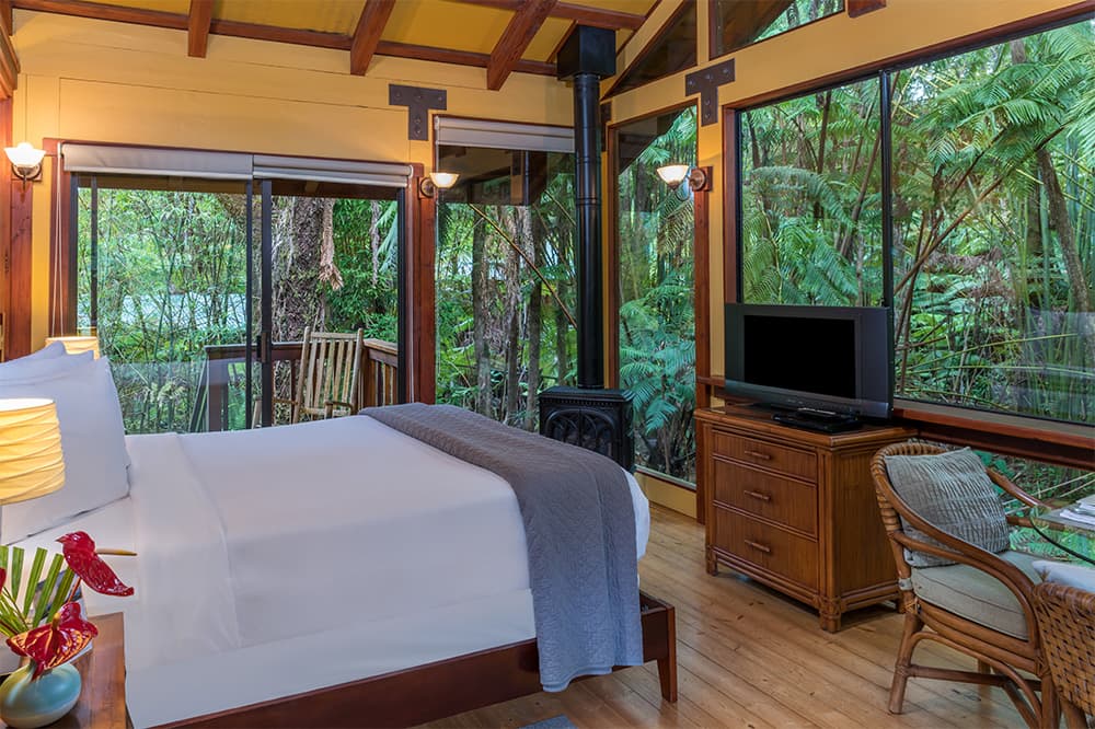 Bed with outdoor views in Hale Kilauea Room