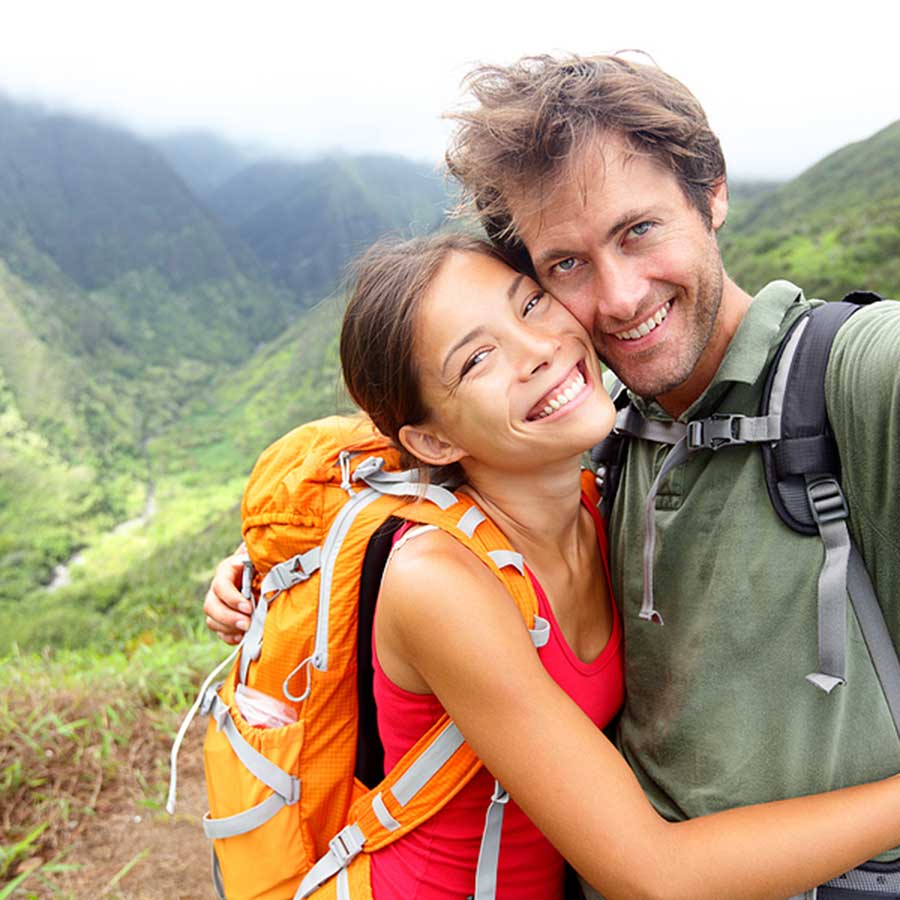 couple posing for a selfie on top of a mountain