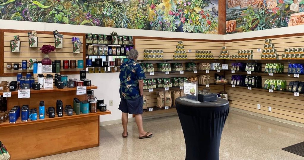 A man looking at shelves of Hawaii coffee beans at Kau Coffee Mill