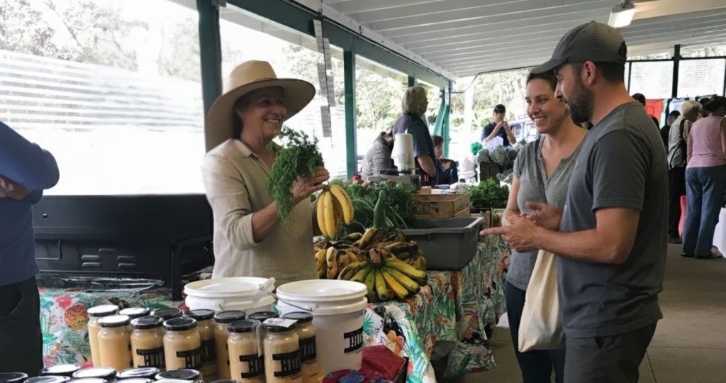A man and woman shopping for fresh produce at the Cooper Center Farmers Market in Volcano, HI