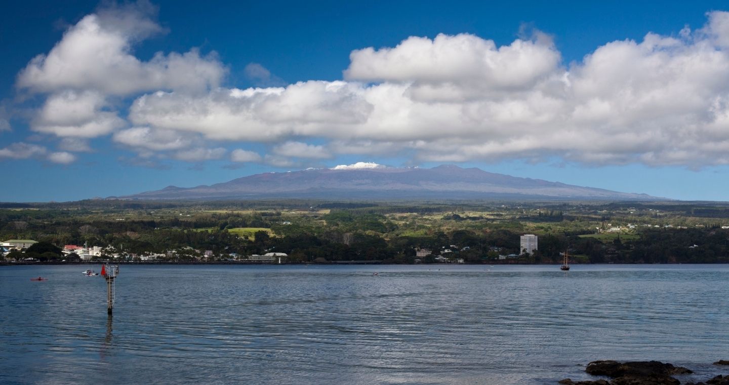 Kayakers paddling in Hilo Bay with Mauna Kea in the background